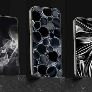 Könnte beinhalten: Drei Smartphones mit unterschiedlichen Bildschirmdesigns. Eines zeigt ein rauchiges weißes Design auf schwarzem Hintergrund, ein anderes ein Muster aus schwarzen Kreisen und das dritte ein fließendes schwarz-weißes Design. Alle Telefone haben silberne Rahmen.