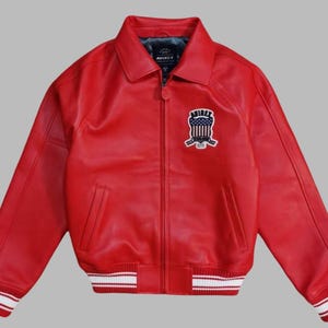 Premium Avirex USA red leather jacket with embroidered logo detailing, classic bomber style, ribbed cuffs and hem, high-quality craftsmanship.
