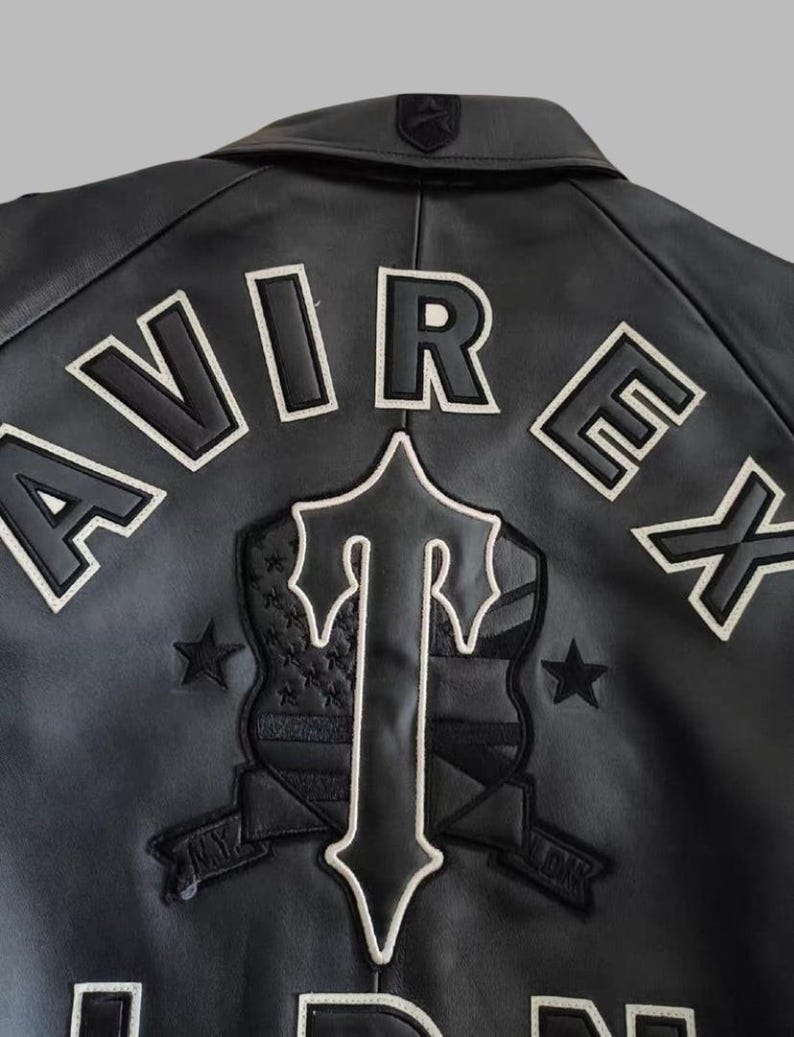 Black Avirex leather jacket featuring bold embroidered Avirex LDN lettering on the back, classic bomber style, ribbed cuffs and hem, premium craftsmanship.