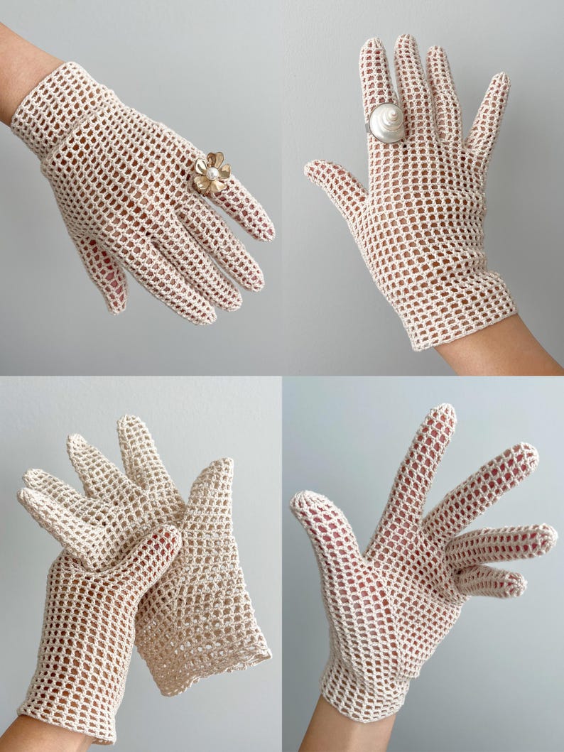 K&ouml;nnte beinhalten: Cremefarbene H&auml;kelhandschuhe mit offenem Gewebe. Die Handschuhe werden in mehreren Ansichten gezeigt, mit einem Blumenring und einem Muschelring an den Fingern. Die Handschuhe haben ein zartes, spitzenartiges Aussehen, und das offene Gewebe l&auml;sst die Haut sichtbar werden.