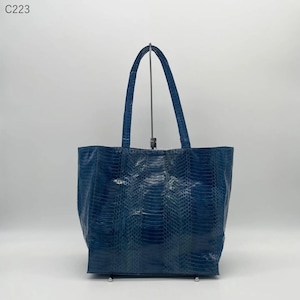 Può includere: Una borsa tote blu con un motivo strutturato simile a quello di un rettile. La borsa ha due manici e una forma rettangolare. La borsa è realizzata in un materiale lucido e ha un interno spazioso. La borsa è di una tonalità blu intenso.