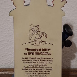 May include: A limited edition figurine from the Best of Mickey Collection, featuring Mickey Mouse from "Steamboat Willie." The figurine depicts Mickey's first appearance, with text describing the film and figurine's details.