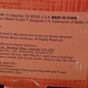 Puede incluir: Primer plano de una caja de producto con texto que incluye "Mattel, Inc., 1999, El Segundo, CA 90245 U.S.A. MADE IN CHINA." La caja tambi&eacute;n presenta el logotipo de Disney/Pixar y texto sobre la canci&oacute;n "You've Got A Friend In Me."