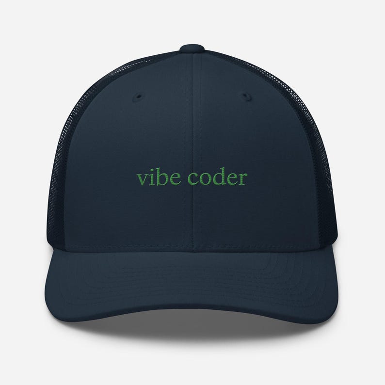 Puede incluir: Gorra de camionero azul marino con parte trasera de malla y visera curva. La gorra presenta el texto bordado "vibe coder" en verde en la parte delantera. Un accesorio casual para el uso diario.