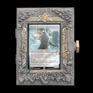 May include: A rectangular display frame with a textured gray stone-like finish and gold-colored accents, housing a Magic: The Gathering trading card titled Kozilek, the Great Distortion. The frame features a rugged, rocky border design.