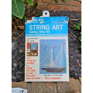May include: A blue and white String Art Sailing Ship Kit, No. 1212, for ages 8 and older. The box features a completed ship image and text that reads, "Just string by number to ready this ship to sail... Fun and easy to make... kit is complete." The wall plaque is 4" x 5".