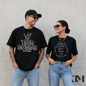 Può includere: Due persone indossano magliette nere con disegni grafici e testo bianchi. Le magliette presentano le frasi "YOUR DESIGN" e "BESTSELLER Your Design here EST 2006". Indossano occhiali da sole e jeans blu. Lo sfondo ha il testo "JUST MOCKS".