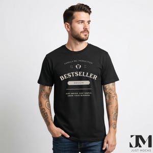 以下が含まれることがあります： 「BESTSELLER」の文字がスタイリッシュなフォントでプリントされた黒いTシャツ。「VANILLA INC. PRODUCTION」と「DESIGN」の文字も含まれています。「JUST MOCKS. JUST SIMPLE. GROW YOUR BUSINESS.」というフレーズがデザインの下に印刷されています。