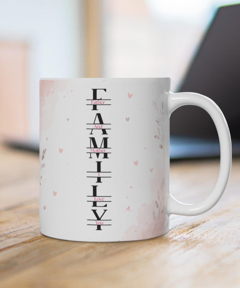 May include: A white ceramic mug featuring a vertical design with the word FAMILY in large black letters. Interspersed between the letters are the words Father, And, Mother, I, Love, You in smaller pink text, accented by soft pink watercolor hearts.