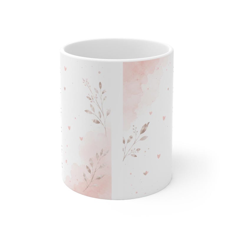 May include: A white ceramic mug featuring a delicate design of soft pink watercolor washes, small scattered hearts, and slender botanical sprigs with muted brown leaves. The pattern wraps around the exterior surface of the cylindrical vessel.