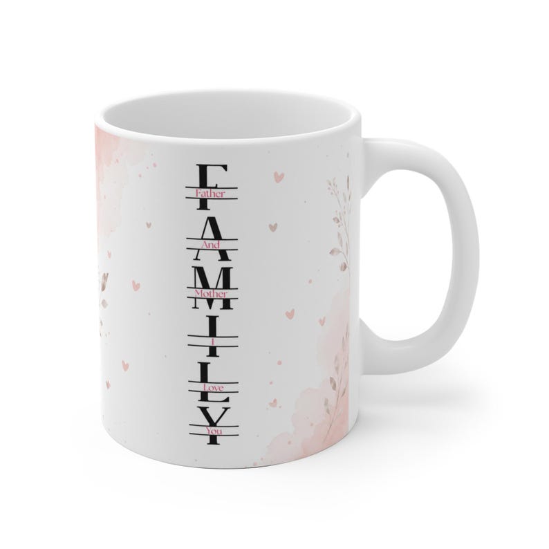 May include: A white ceramic mug featuring a vertical black text design that spells FAMILY with the words Father, And, Mother, I, Love, You integrated horizontally. The mug is decorated with soft pink watercolor clouds and small heart accents.