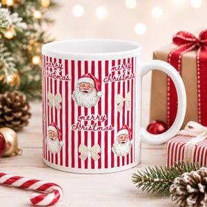 May include: A white ceramic mug featuring a repeating pattern of red and white vertical stripes, illustrations of Santa Claus faces, and small cream-colored bows. The text "merry christmas" is printed in a cursive script throughout the design.