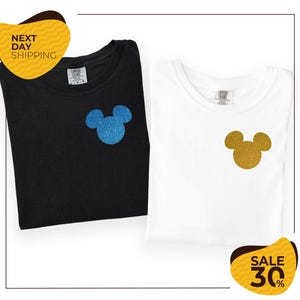 two t-shirts with Mickey Mouse designs, one black and one white, both with glittery Mickey Mouse ears. The t-shirts are folded and placed next to each other, and there are yellow and black sale signs indicating a 30% discount.