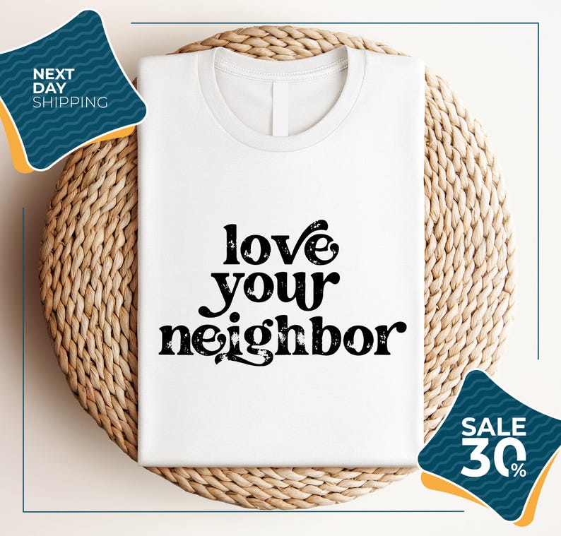 a white t-shirt with the text "LOVE YOUR NEIGHBOR" printed on it, displayed on a woven placemat. The t-shirt is placed on a round wicker basket, and there are two sale signs in the image, one indicating a 30% discount and the other promoting next day shipping.