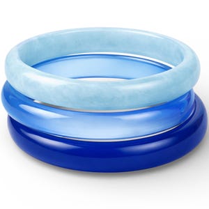 May include: Three blue bangles stacked on top of each other. The top bangle is a light blue with a marbled texture, the middle is a medium blue, and the bottom is a deep, glossy blue. The bangles are round and smooth.