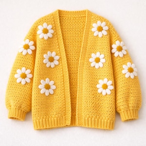 May include: A yellow crochet cardigan adorned with white and yellow daisy appliqués. The open-front sweater features long sleeves and a ribbed hem and cuffs. The daisy accents are evenly spaced across the front and sleeves, creating a cheerful, handmade aesthetic.