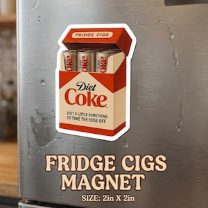 Puede incluir: Un imán para nevera con un diseño parodia de un paquete de cigarrillos, etiquetado como "Fridge Cigs". El diseño incluye el logotipo de "Diet Coke" y la frase "Just a little something to take the edge off". El imán mide 5 cm x 5 cm.
