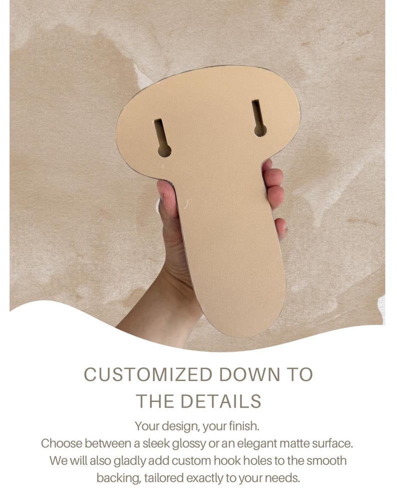 May include: A light beige, mushroom-shaped object with a smooth, flat backing featuring two vertical keyhole slots for mounting. The text below reads: CUSTOMIZED DOWN TO THE DETAILS. Your design, your finish. Choose between a sleek glossy or an elegant matte surface. We will also gladly add custom hook holes to the smooth backing, tailored exactly to your needs.