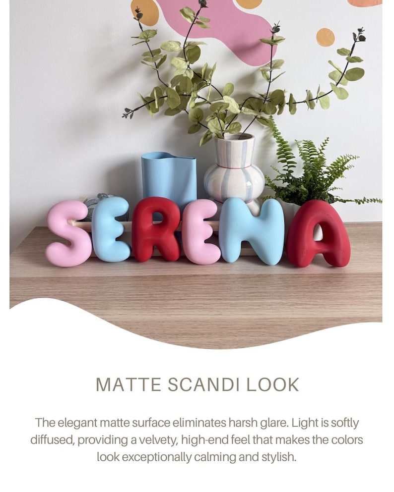 May include: A set of six individual 3D letters spelling the name SERENA, featuring a smooth matte finish. The letters are colored in a sequence of light pink, light blue, red, light pink, light blue, and red, arranged in a horizontal line.