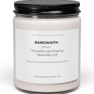 Puede incluir: Una vela de soja blanca vertida a mano en un tarro de vidrio con tapa negra. La etiqueta dice "BANDWIDTH (sustantivo) La forma educada de decir 'absolutamente no'". La vela pesa 255 gramos.