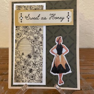 Puede incluir: Tarjeta de felicitaci&oacute;n hecha a mano con un dise&ntilde;o floral y de abejas. La tarjeta presenta una pancarta decorativa que dice "Sweet as Honey". Una pegatina de una mujer con un vestido vintage est&aacute; en el lado derecho.