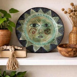 Plato de cerámica vintage con cara de sol, pintado a mano, arte popular, decoración de pared, azul y verde.