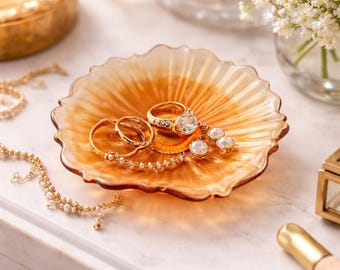 Centro de mesa con pedestal de vidrio prensado color melocotón y caléndula vintage y borde festoneado.