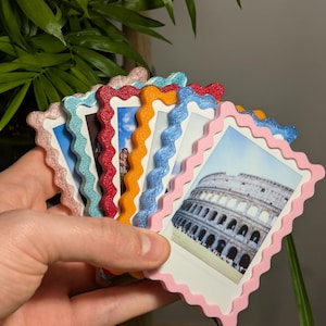 Puede incluir: Una colección de marcos de fotos coloridos con bordes festoneados, cada uno con una imagen diferente. Los marcos son en tonos de rosa, azul, rojo, naranja y dorado brillante. Un marco muestra una foto del Coliseo.