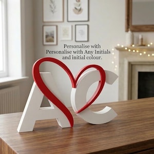 May include: White wooden initials "A" and "C" with a red heart-shaped accent, displayed on a wooden surface. The text "Personalise with Any Initials and initial colour" is visible in the background. Decorative home decor.