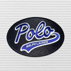 May include: A white ceramic mug with a black handle and the text "But First, Coffee" in a bold, black font. The mug is set against a blurred background, suggesting a cozy setting.