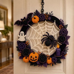 Op de afbeelding: Een ronde Halloween-krans met een gehaakt zwart frame en een wit spinnenweb in het midden. De decoraties bestaan uit een zwarte vleermuis, een wit spookje, een zwarte spin, oranje pompoenen, paarse en zwarte gehaakte bloemen en een paarse kaars.