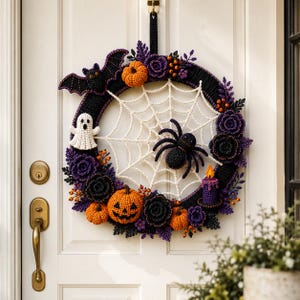 K&ouml;nnte beinhalten: Ein runder Halloween-Kranz mit einer schwarzen H&auml;kelbasis und einem wei&szlig;en Spinnennetz in der Mitte. Er ist mit einer schwarzen Spinne, einem wei&szlig;en Geist, einer Fledermaus, orangefarbenen K&uuml;rbissen, violetten und schwarzen Bl&uuml;ten verziert.