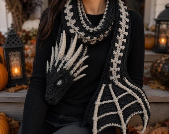 Könnte beinhalten: Ein gehäkelter Schal in Schwarz und Beige mit einem Drachenkopf-Design, strukturierten Stacheln, einem langen Körper mit wirbelartigem Muster und einem breiten, gewebten Schwanzende. Der Schal besteht aus dunklem Garn mit hellen Akzenten.