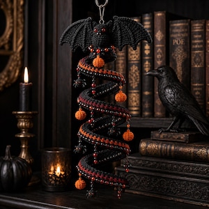 May include: A hanging crochet decoration featuring a black bat at the top with red eyes, attached to a long, black and orange spiral structure. The spiral is adorned with small orange crocheted pumpkins, black spider charms, and red beads.