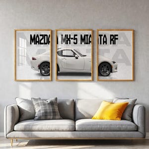 Peut inclure: Un triptyque composé de trois cadres muraux représentant une voiture de sport Mazda MX-5 Miata RF blanche. La voiture est illustrée de profil sur les trois cadres, avec le texte MAZDA MX-5 MIATA RF imprimé en lettres noires sur le haut.