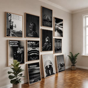 Könnte beinhalten: Eine Galeriewand mit zehn schwarz-weißen gerahmten Postern zum Thema Formel 1, die Rennwagen, Fahrer mit Helmen und Texte wie BOX, BOX, NOTHING, JUST AN INCIDENT und SAINZ zeigen, angebracht an einer hellen Wand.