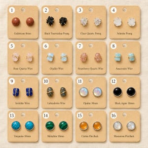 May include: Sixteen pairs of stud earrings displayed on individual tan cards, numbered 1 through 16. The collection includes various gemstones like goldstone, black tourmaline, clear quartz, selenite, rose quartz, opalite, strawberry quartz, amazonite, sodalite, labradorite, black agate, turquoise, malachite, citrine, and moonstone in round, prong, and wire-wrapped styles.