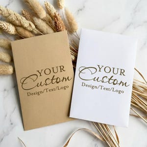 May include: A white ceramic mug with a black handle and the text "But First, Coffee" in a handwritten style. The mug is on a white surface. The mug is approximately 4 inches tall.