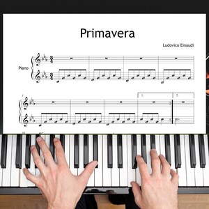 Può includere: Mani che suonano il pianoforte, con spartito di "Primavera" di Ludovico Einaudi. I tasti del pianoforte sono bianchi e neri, e lo spartito è in bianco e nero.