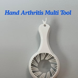 May include: A white hand arthritis multi-tool with a handle and a circular opening with radial supports. The text "Hand Arthritis Multi Tool" is in blue above the tool.