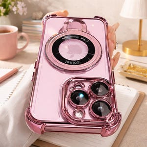 May include: A pink phone case with a ring holder and camera lens protector. The case has a clear back and a metallic pink frame. The ring holder has the text "New phone case" and "colnel". The case has a protective cover for the phone's camera lenses.