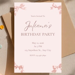 Puede incluir: Una invitación de cumpleaños rosa claro con el texto "You're Invited To Juliana's BIRTHDAY PARTY" y detalles para el 12 de mayo de 2026. La invitación está decorada con lazos rosas y descansa sobre una superficie de tono neutro.