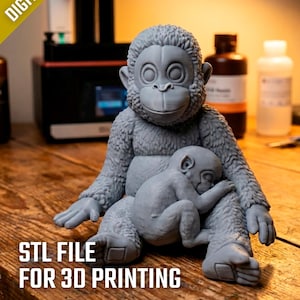 May include: A gray 3D-printed sculpture of a mother monkey cradling a baby monkey. The sculpture is on a wooden surface. Text in the image reads "DIGITAL FILE" and "STL FILE FOR 3D PRINTING".