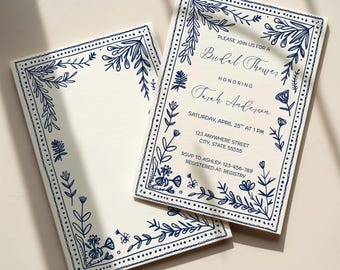 May include: Two rectangular cream-colored cards featuring a dark blue hand-drawn floral border. The right card displays text: PLEASE JOIN US FOR A Bridal Shower HONORING Tarah Anderson SATURDAY, APRIL 25TH AT 1 PM 123 ANYWHERE STREET CITY, STATE 55555.