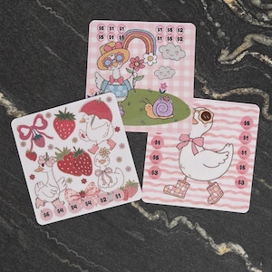 May include: Three square stickers featuring cartoon ducks in various settings. One shows a duck with a rainbow and snail, another features strawberries and bows, and the third depicts a duck in rain boots. Each sticker includes circular price labels.