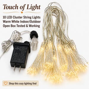 May include: A set of 10 LED cluster string lights with warm white bulbs on thin silver wires. The set includes a black power adapter and a connector. Text on the image reads: Touch of Light, 10 LED Cluster String Lights Warm White Indoor/Outdoor.