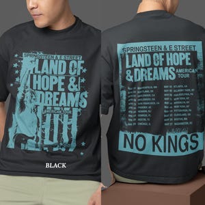 Puede incluir: Camiseta negra con un diseño turquesa. La parte delantera muestra "SPRINGSTEEN & E STREET LAND OF HOPE & DREAMS AMERICAN TOUR". La parte trasera tiene fechas de la gira y el texto "NO KINGS".