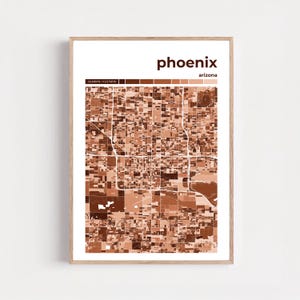 Puede incluir: Una impresión enmarcada que presenta un mapa detallado de Phoenix, Arizona, en tonos marrones y blancos. El nombre de la ciudad se muestra en la parte superior, con coordenadas debajo. El mapa es una representación geométrica del diseño de la ciudad.