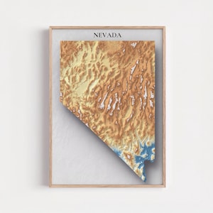 May include: Framed topographic map of Nevada, showing a 3D rendering of the state's terrain. The map uses a colour gradient, from tan and yellow to blue, with the word "NEVADA" at the top. The frame is made of light-coloured wood.