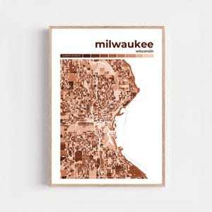 Puede incluir: Impresión enmarcada que presenta un mapa detallado de Milwaukee, Wisconsin, en tonos marrones. El nombre de la ciudad se muestra en negrita sobre el mapa, con el nombre del estado debajo. Coordenadas en la parte inferior.